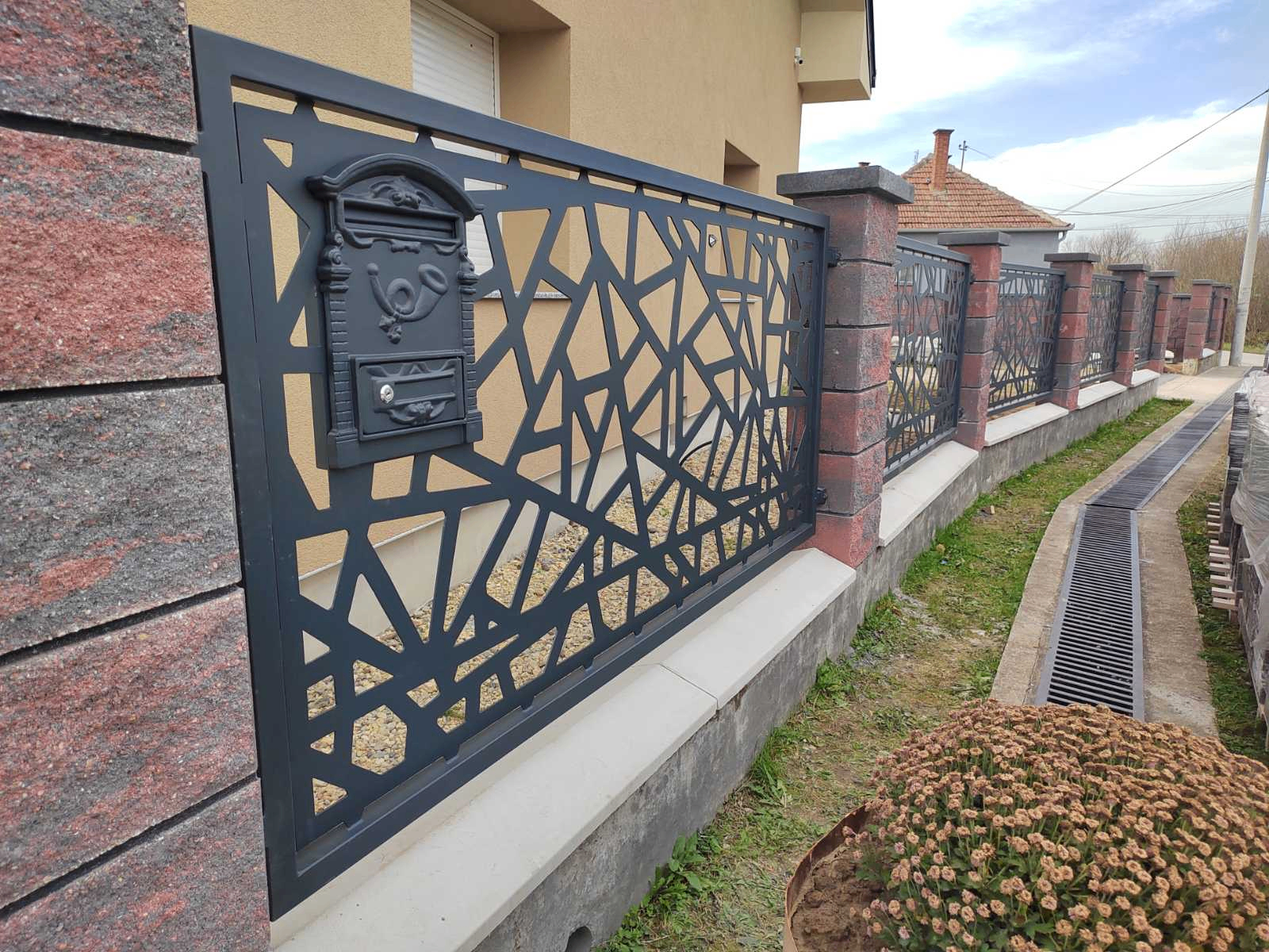 Detalj antracit ulične ograde sa organskim laserski sečenim šarama i poštanskim sandučetom