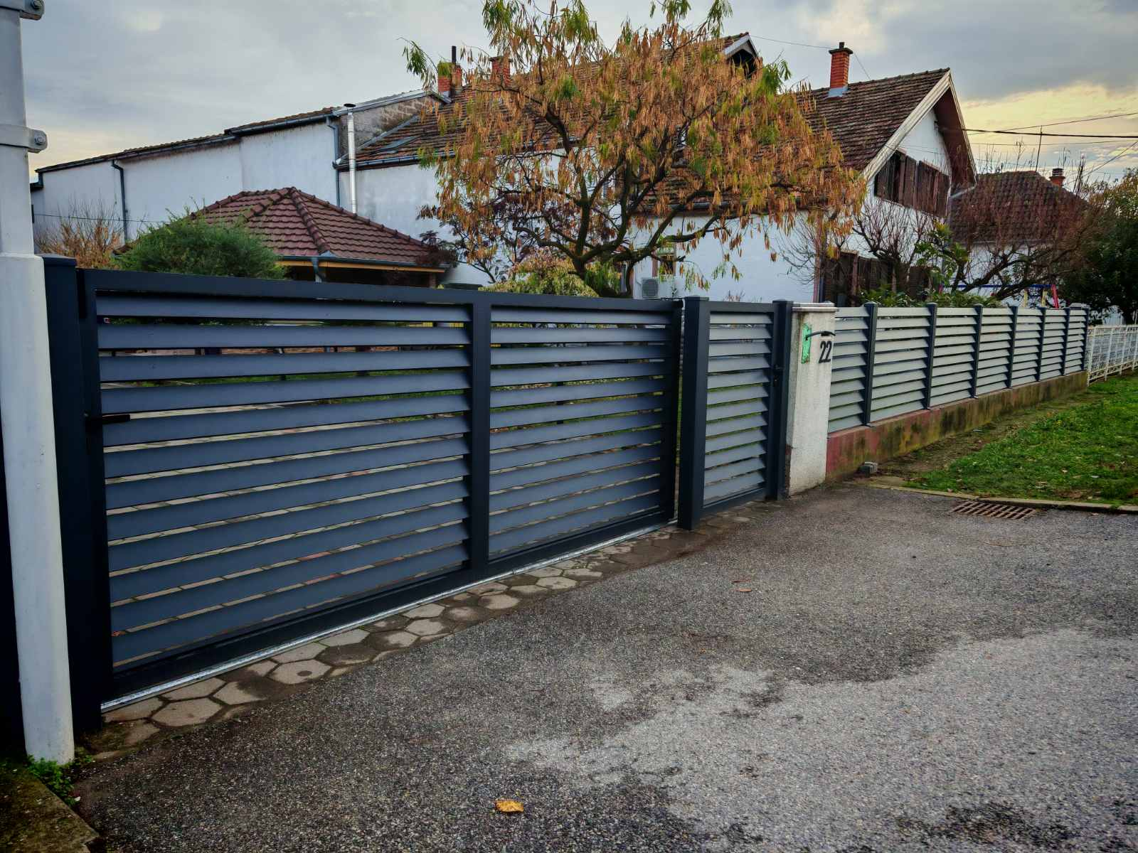 Tamna horizontalna kapija i ograda duž dvorišta