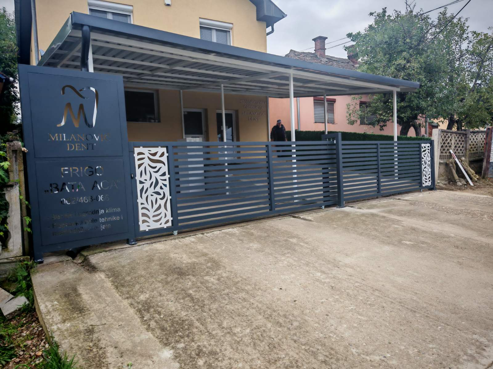 Poslovni ulaz sa metalnom nadstrešnicom i kliznom kapijom