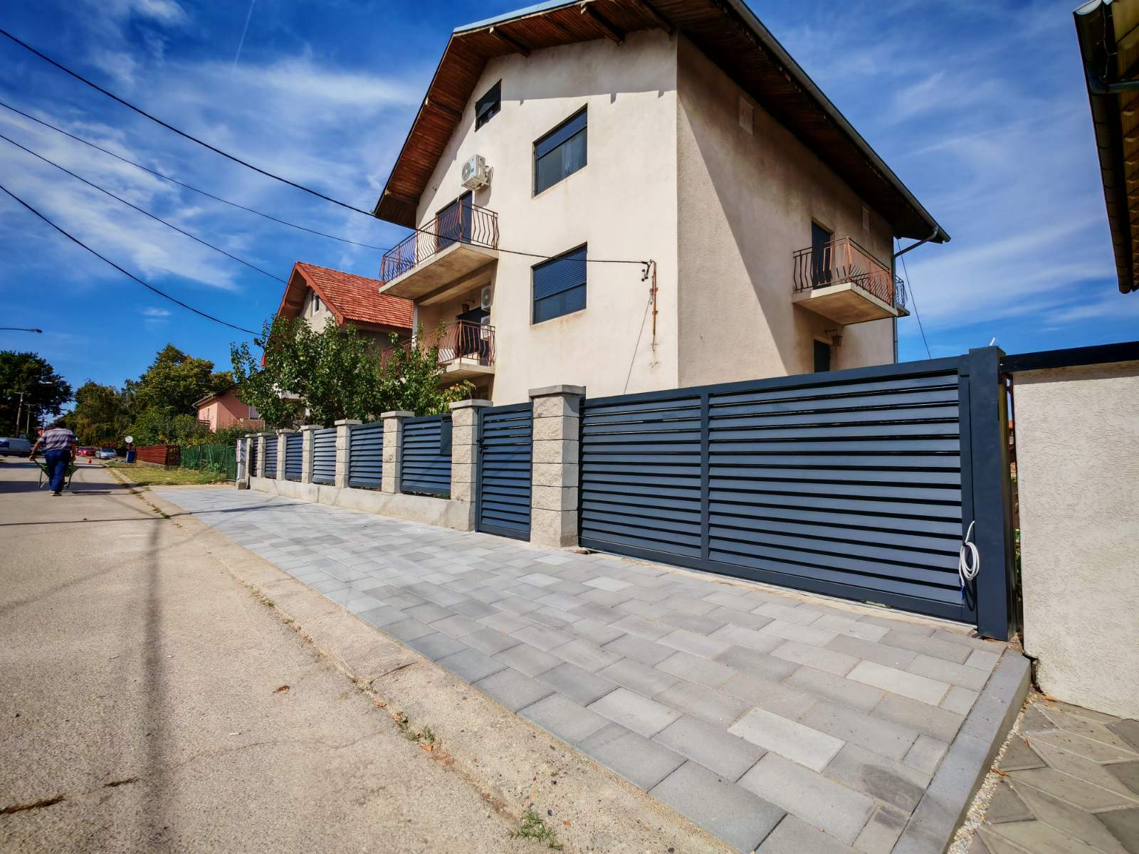 Antracit kapija i ograda ispred kuće uz trotoar
