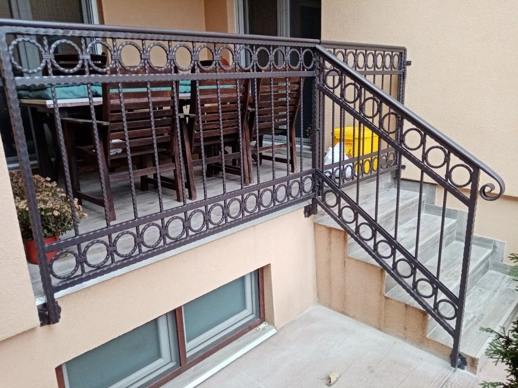Tamno braon dekorativni gelender sa kružnim detaljima na terasi i stepeništu