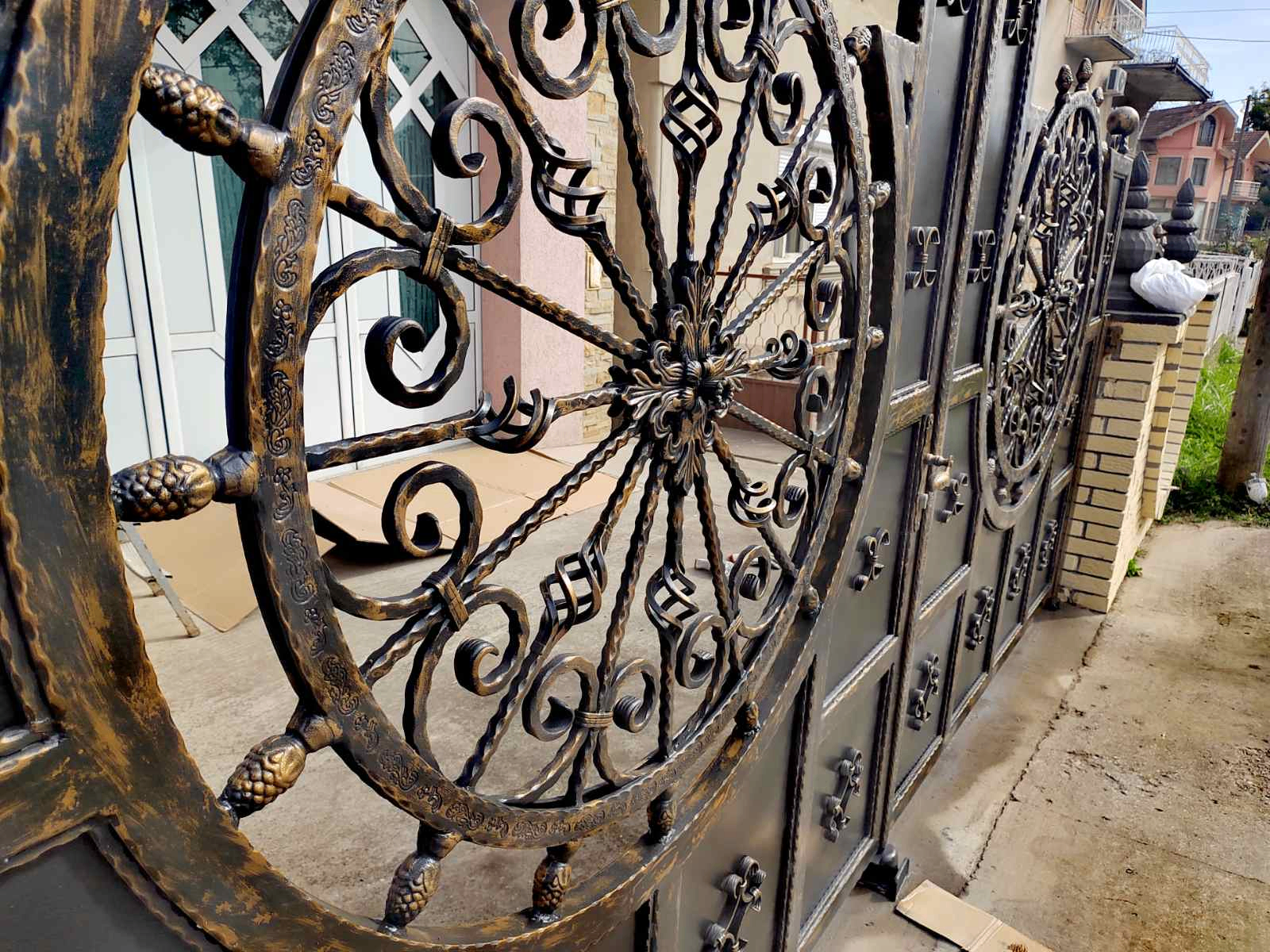 Detalj kovane dvorišne kapije sa velikim kružnim ornamentalnim motivom