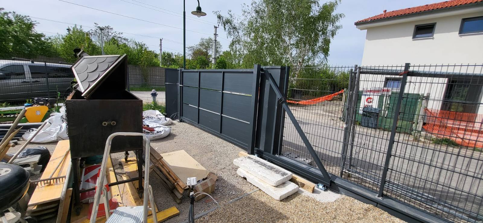 Antracit klizna kapija u fazi montaže sa pratećom panel ogradom