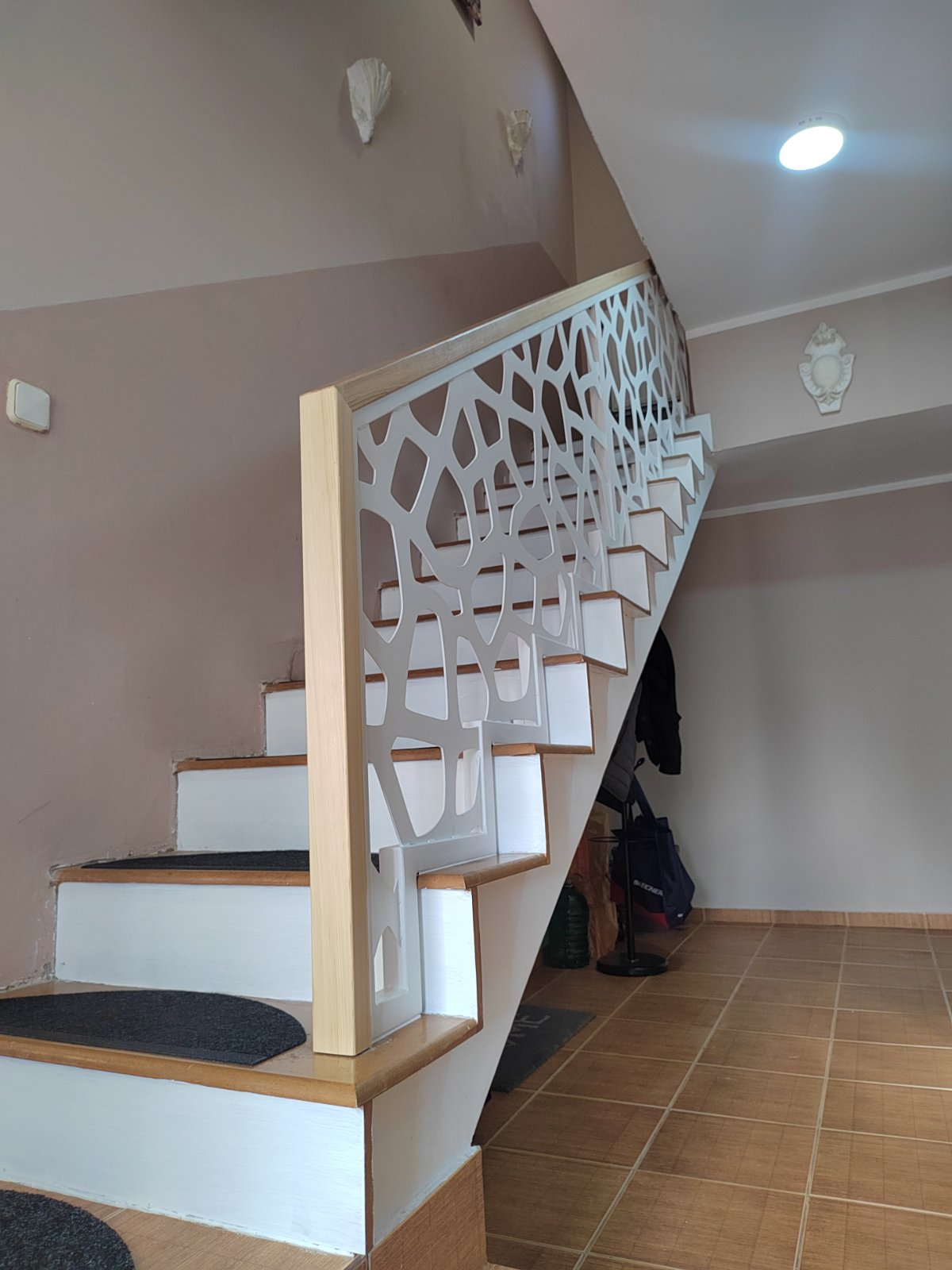 Pogled sa strane na beli dekorativni gelender uz stepenice i hodnik