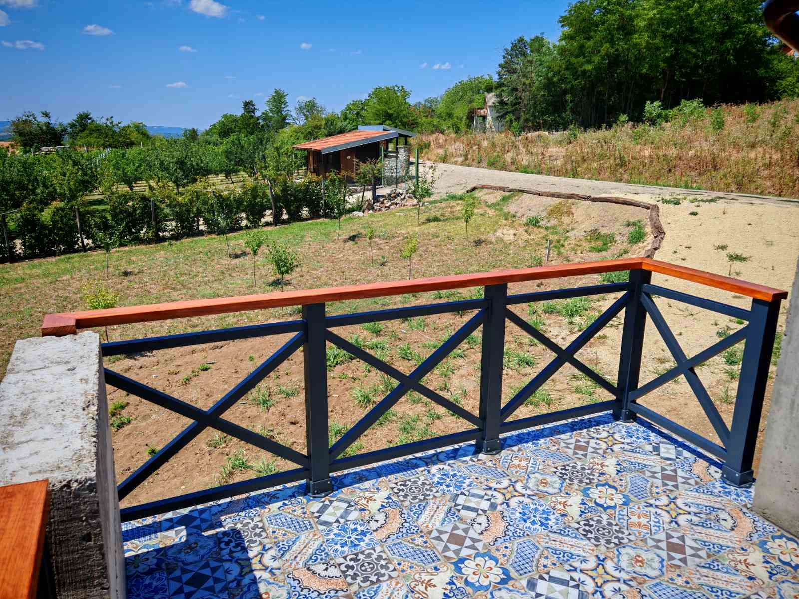 Crni terasni gelender sa ukrštenim poljima i drvenim rukohvatom