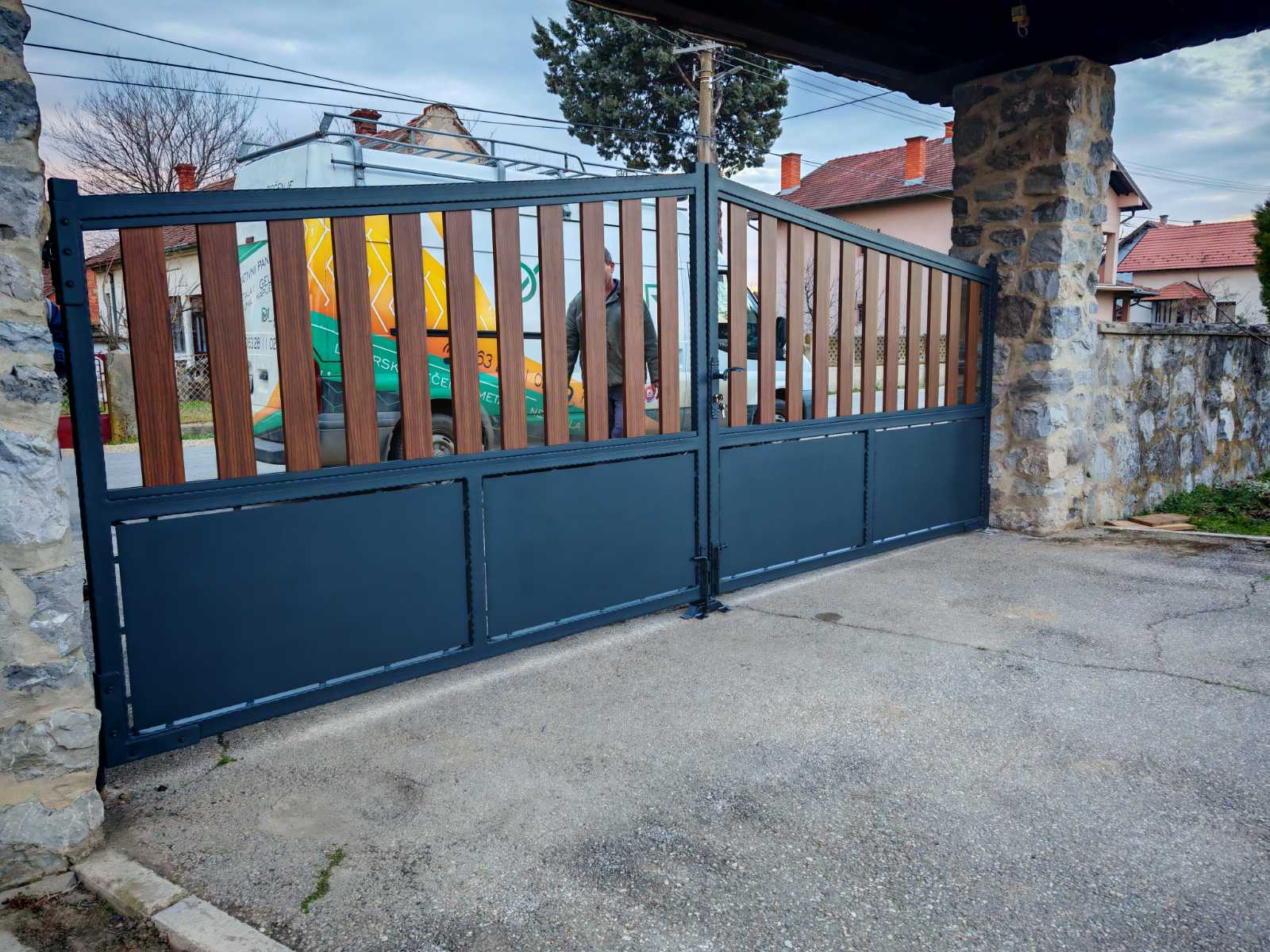 Dvokrilna kapija sa tamnim ramom i vertikalnom ispunom u dezenu drveta
